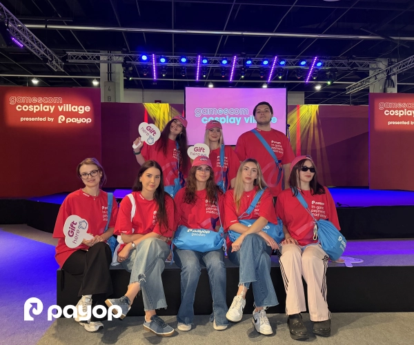 Payop team members in matching red t-shirts at the Gamescom 2026 Cosplay Village stage.